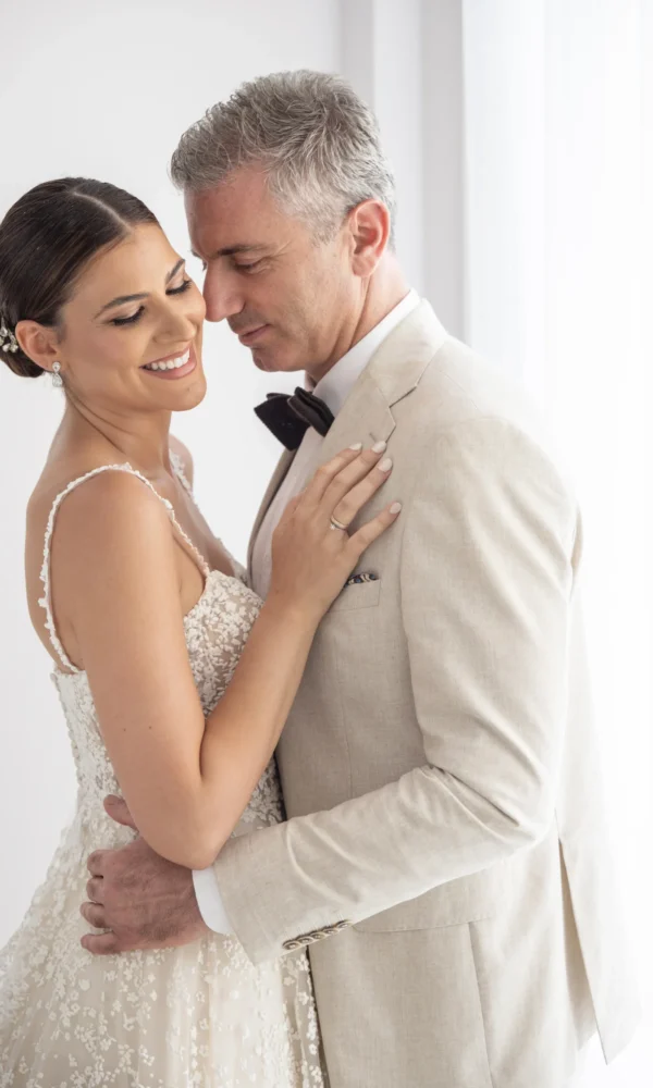 νύφη και γαμπρός ποζάρουν αγκαλιασμένοι