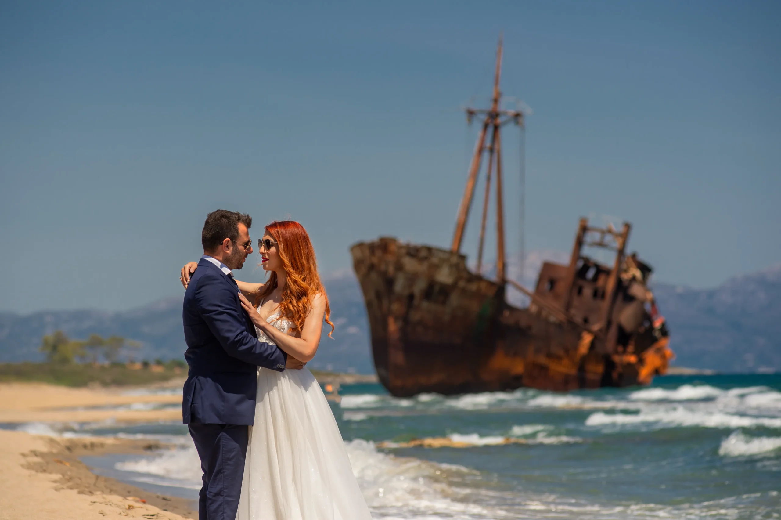 νύφη και γαμπρός ποζάρουν μπροστά σε ναυαγισμένο καράβι