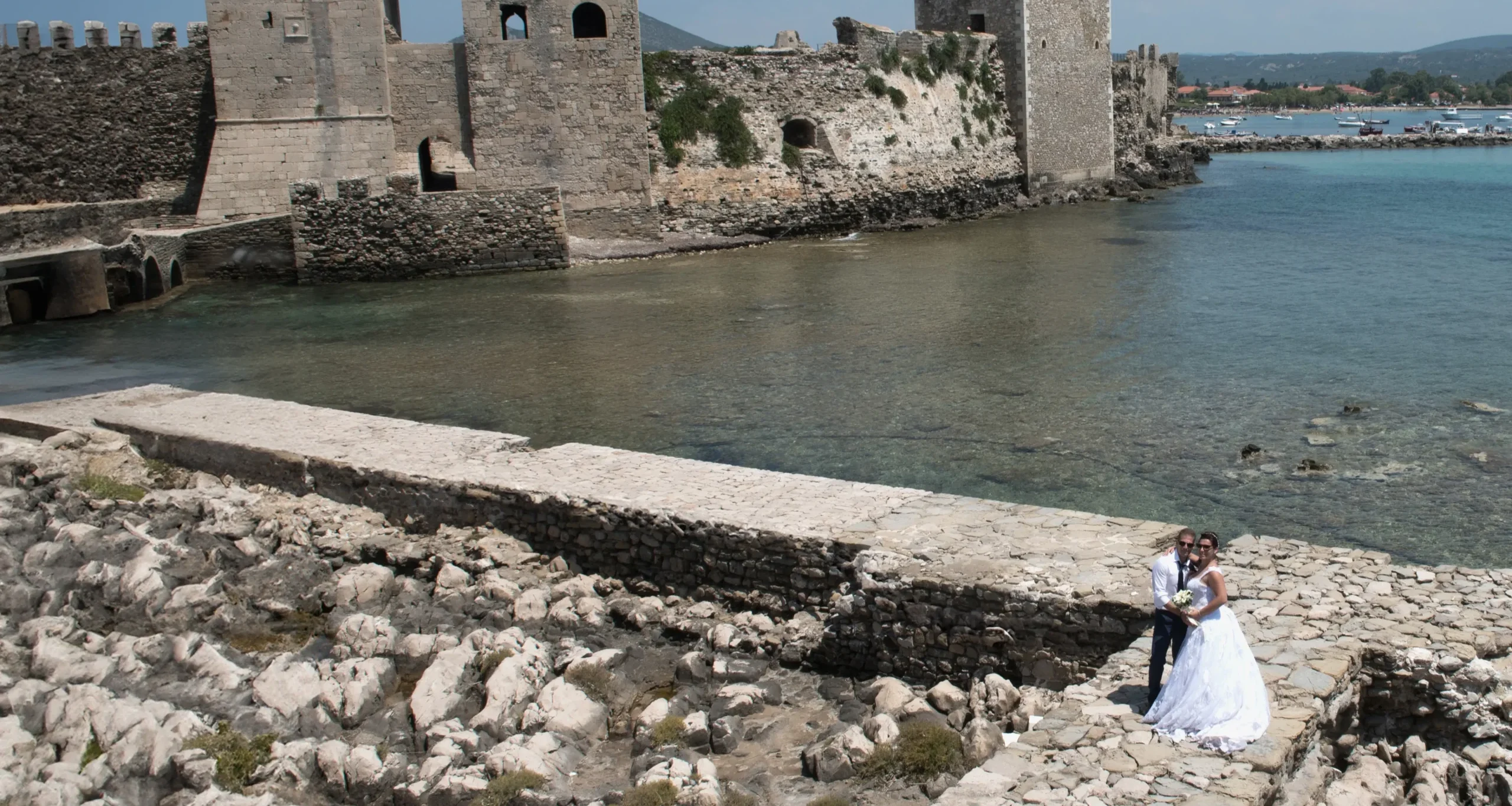 νύφη και γαμπρός με φόντο θάλασσα και κάστρο