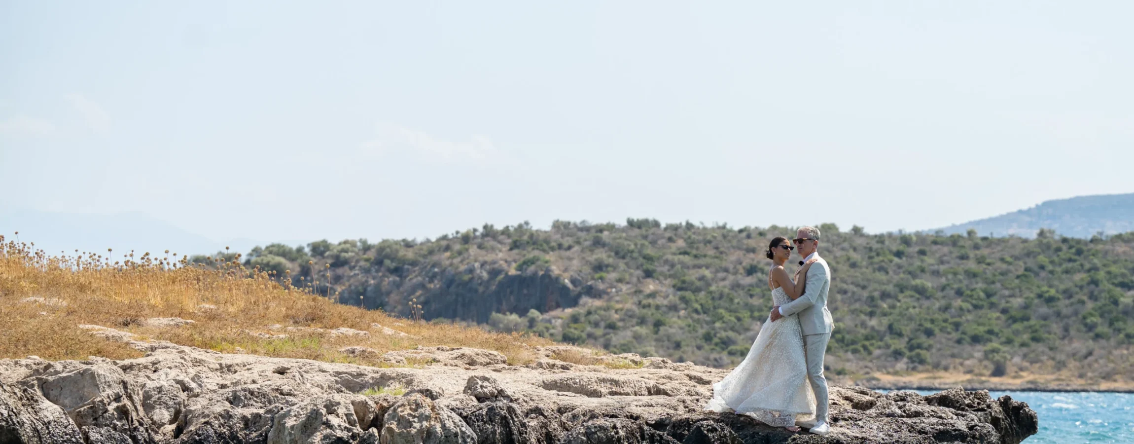 νύφη και γαμπρός σε βράχο στη θάλασσα